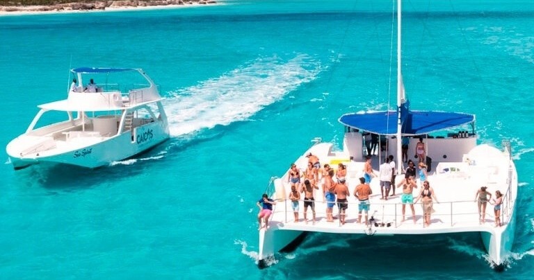 Two boats on turquoise water with passengers enjoying the view.