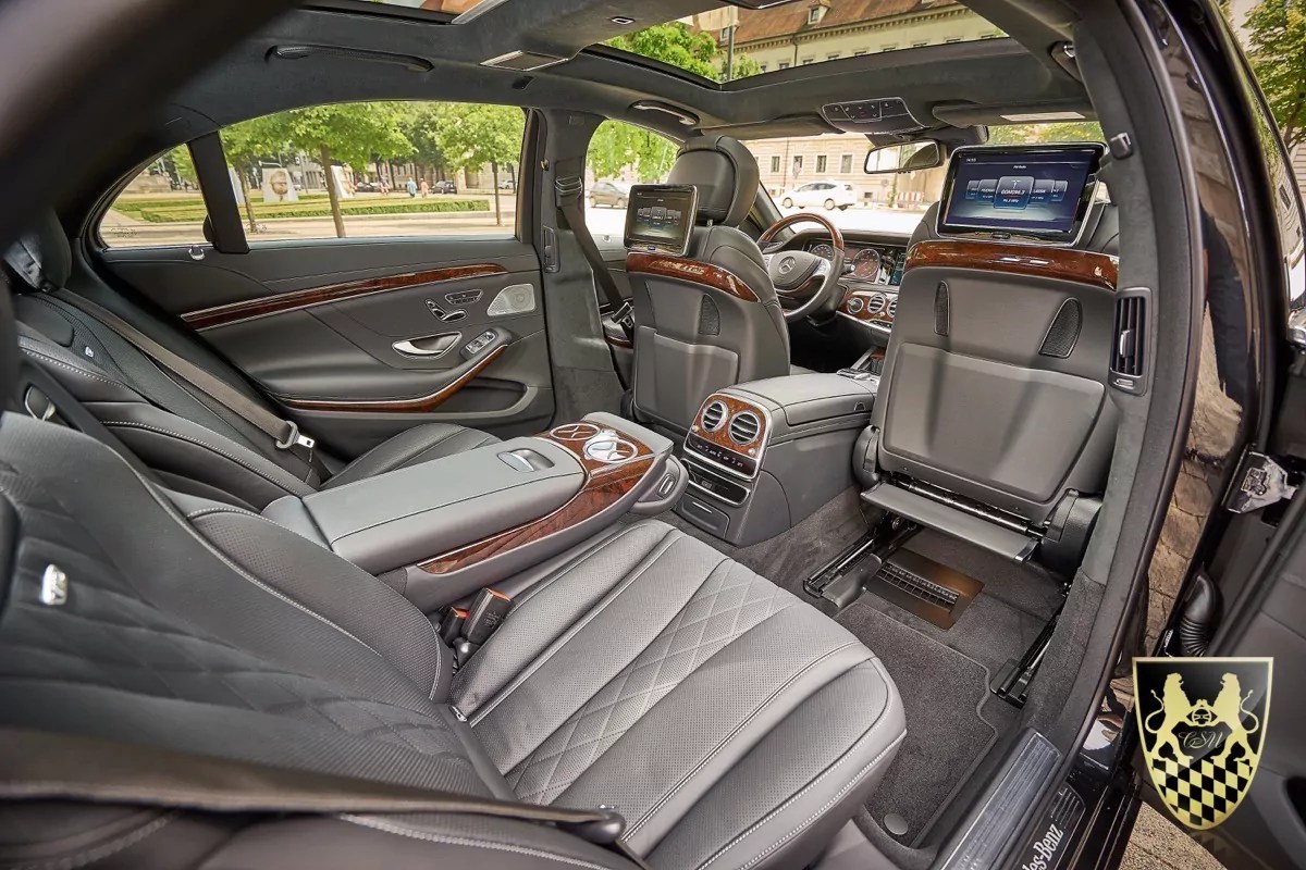 Luxurious car interior with leather seats and rear entertainment screens.