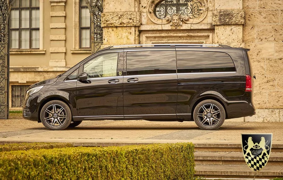 Black van parked in front of a historic building with intricate stonework.
