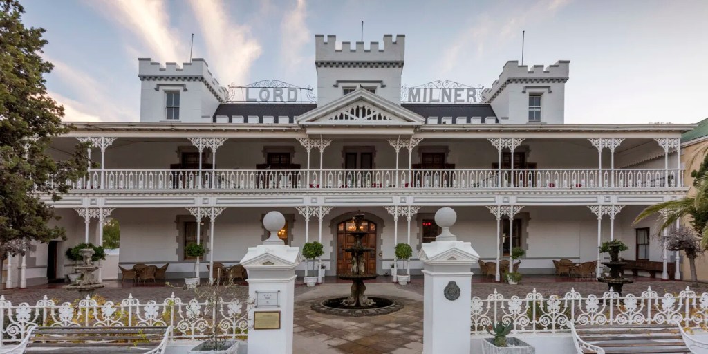 Historical white building with two-story veranda and a central tower.