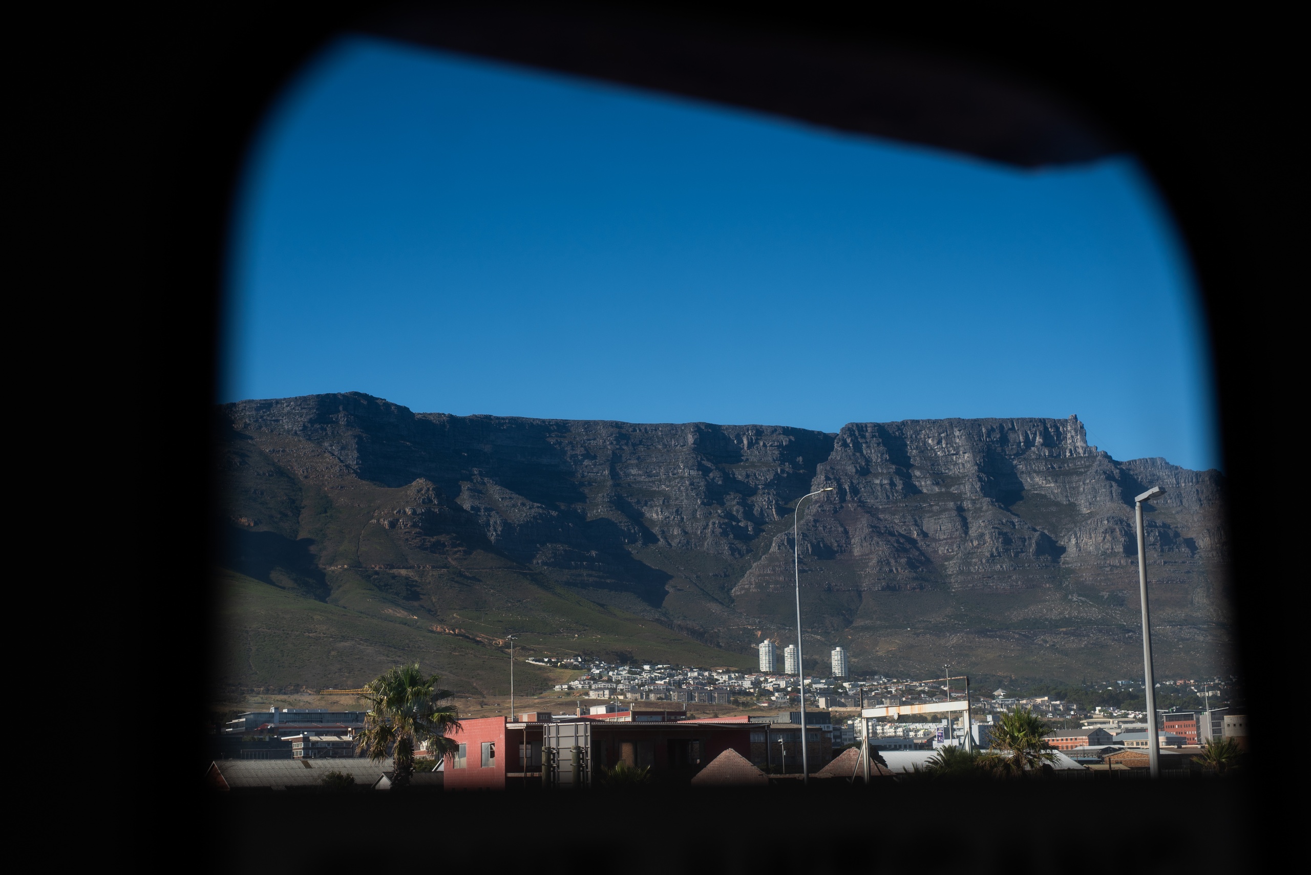 View of Table Mountain through a window under a clear blue sky.