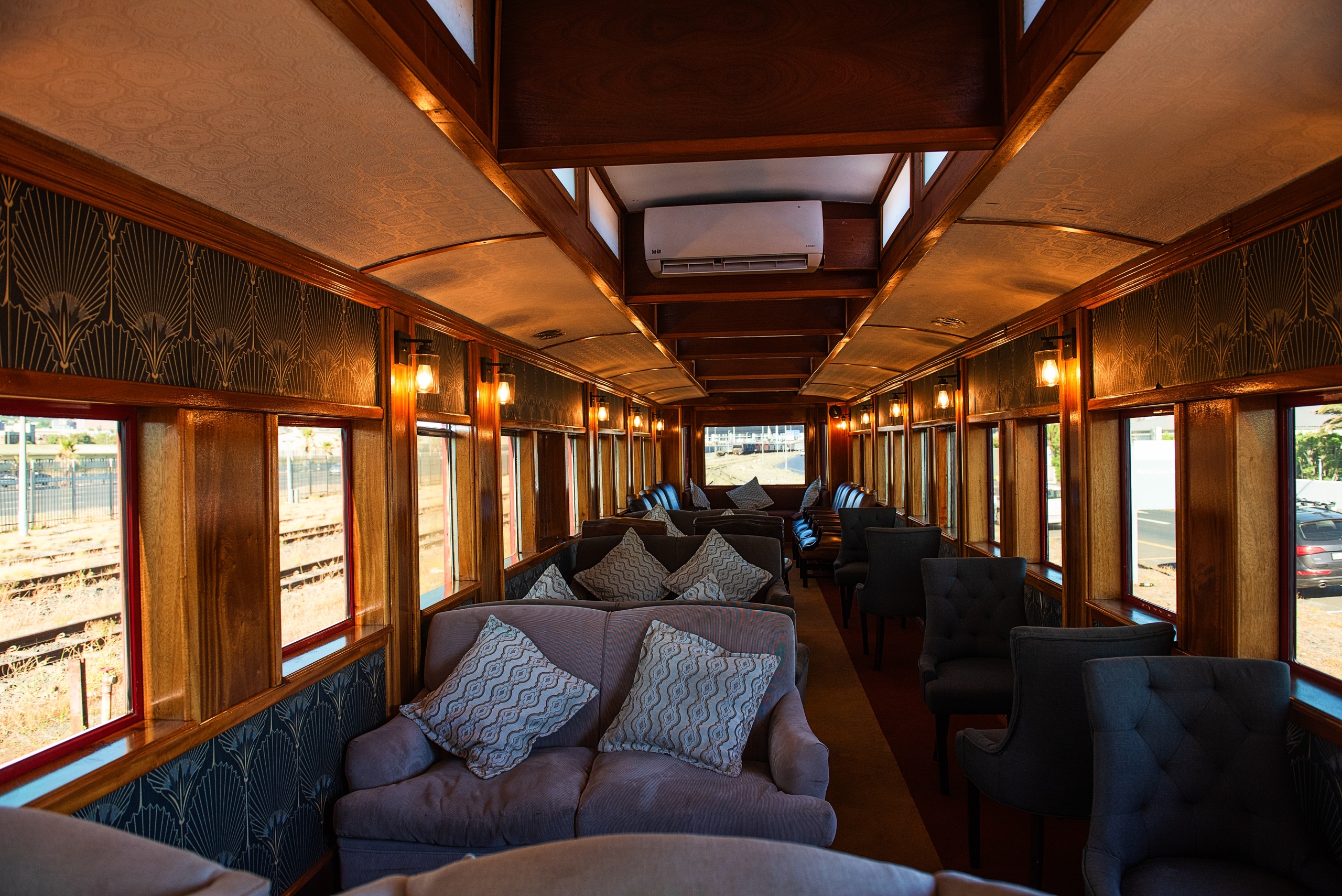 Luxurious vintage train interior with plush seating and wooden paneling.