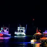 Boats decorated with colorful lights on the water at night.