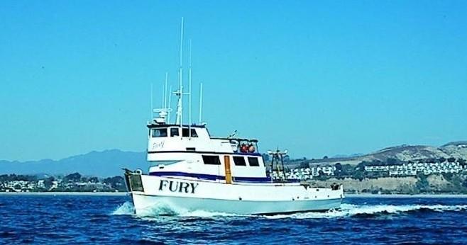 White boat named Fury on the ocean with a clear blue sky.