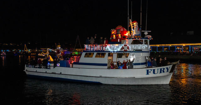 Decorated boat with lights and festive figures at night parade.
