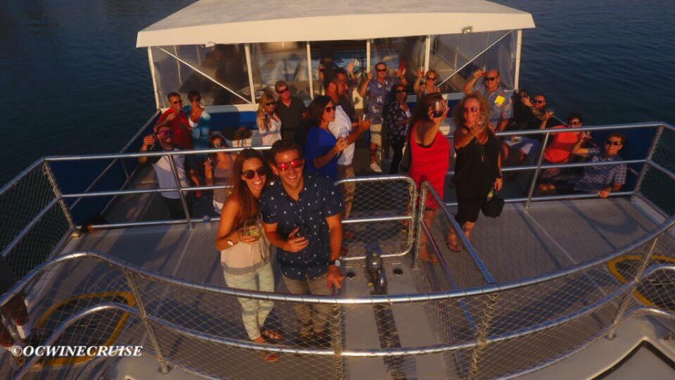 A group of people on a boat, smiling and posing for a photo.