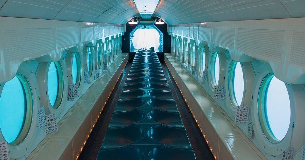 Interior view of a passenger submarine with circular windows.