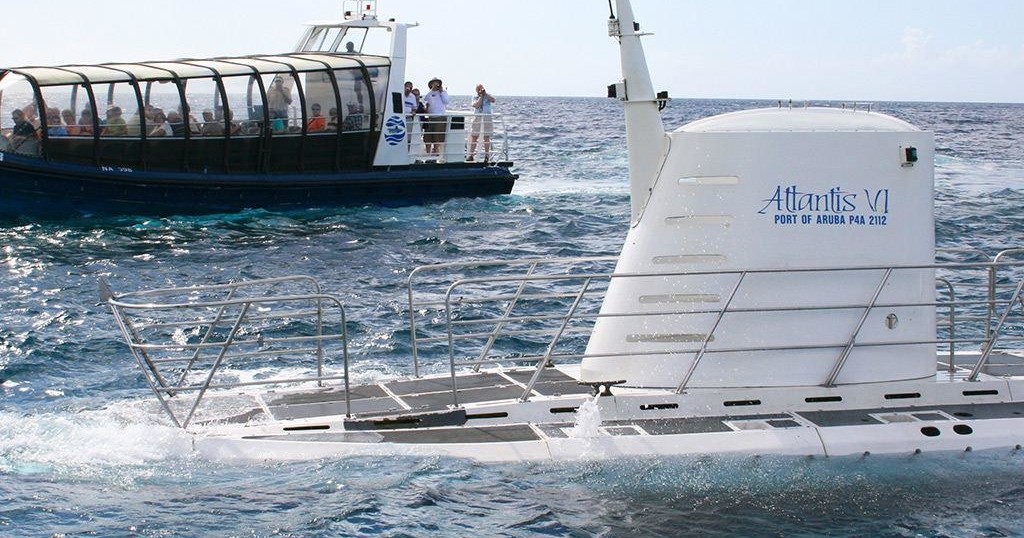 A submarine and boat on the ocean's surface.