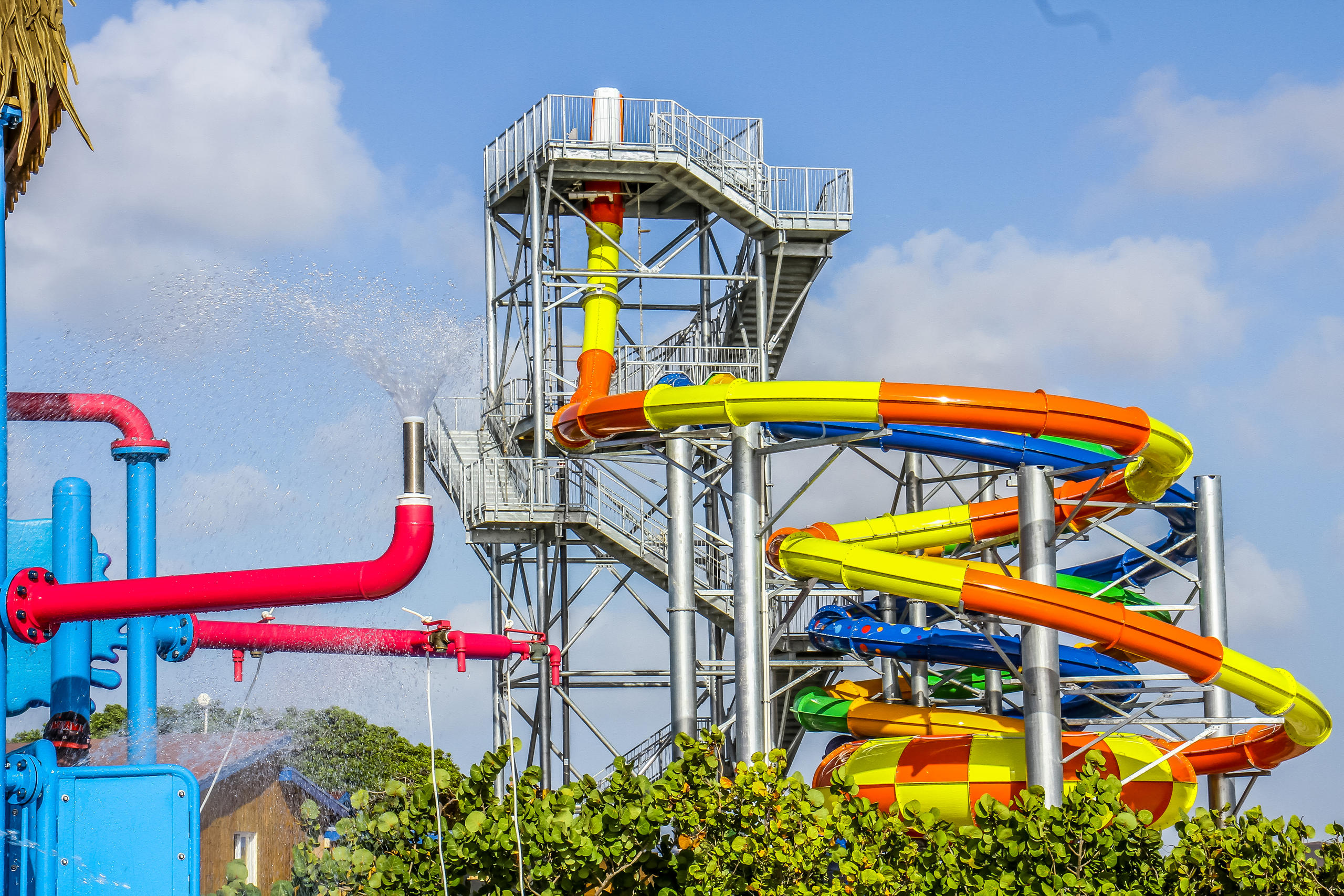 Colorful water slides and spray features at an outdoor water park.