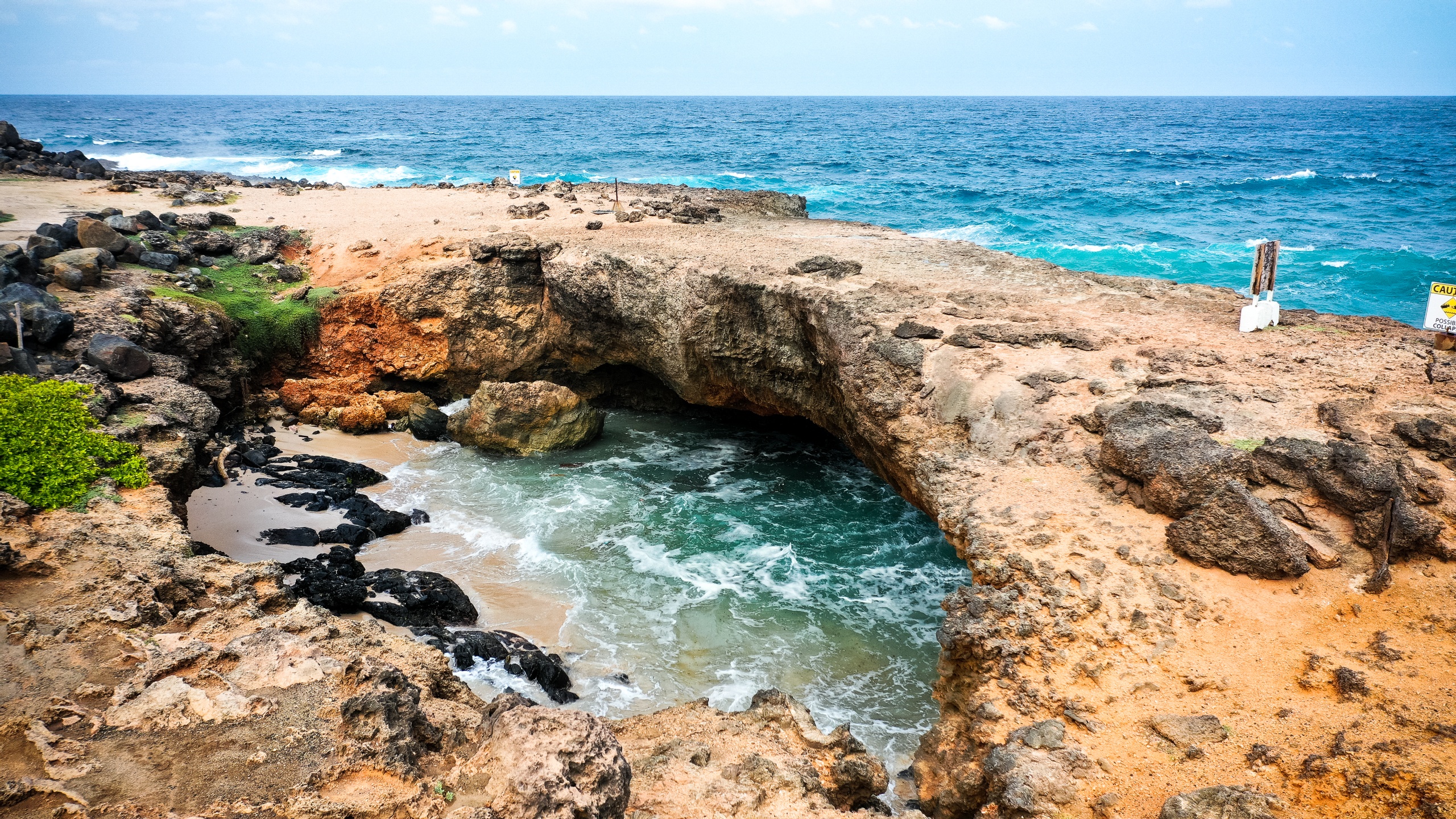 Rocky coastal landscape with natural arch over the sea.