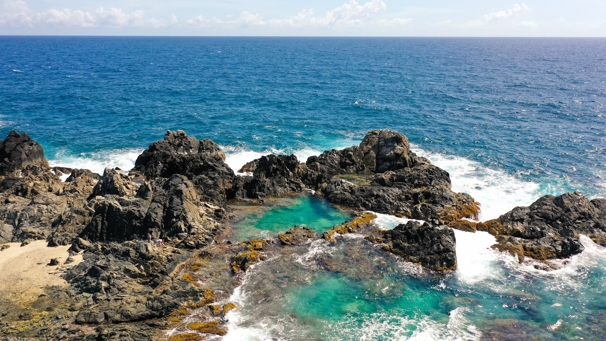 Rocky coastline with tidal pools and ocean waves.