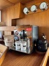 Coffee maker with mugs and coffee beans on a wooden counter