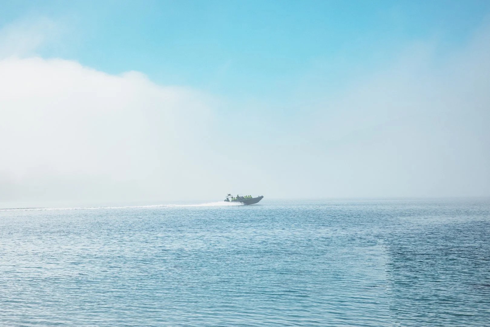 Small boat on calm blue water under a clear sky