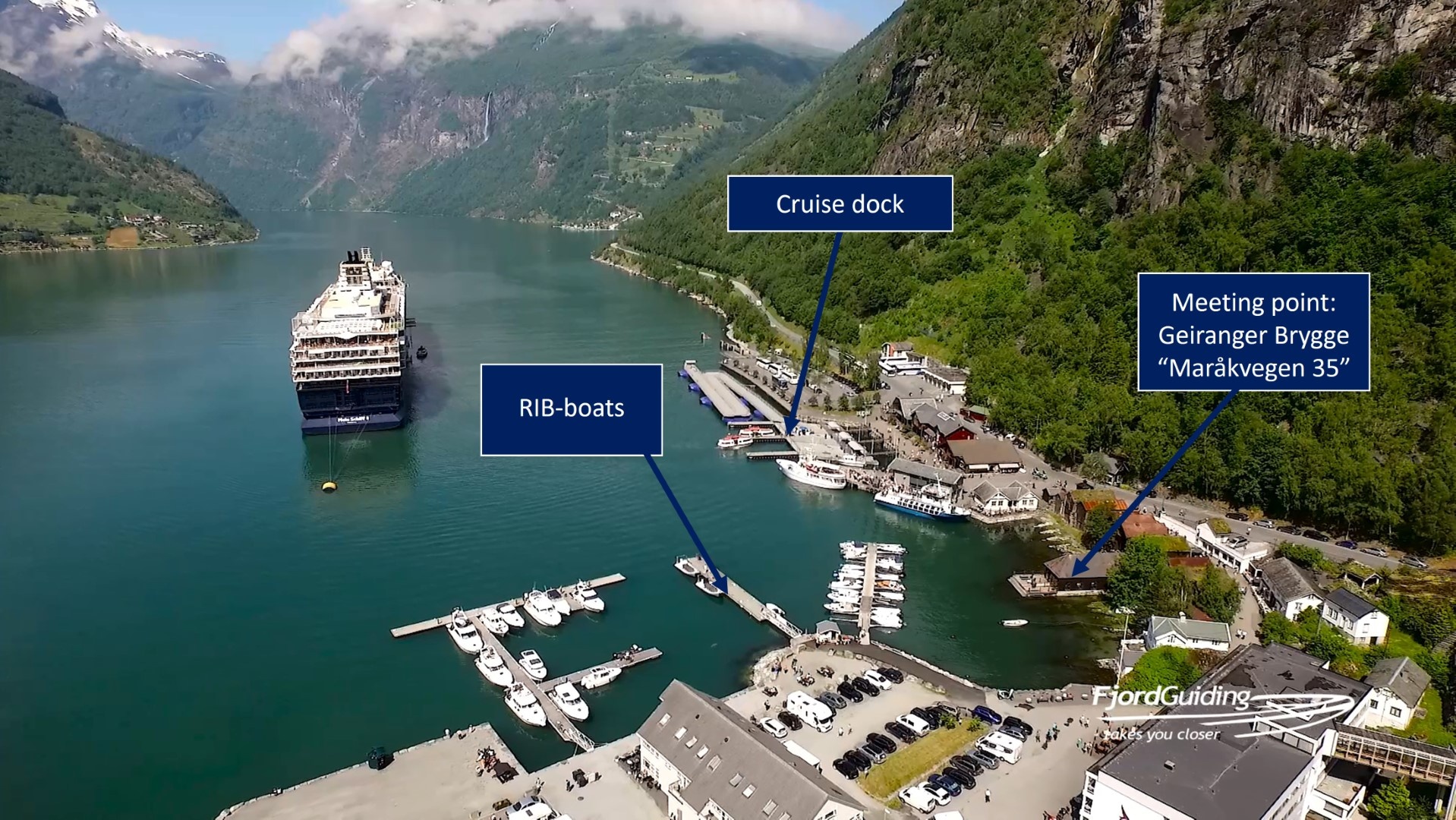 Aerial view of Geirangerfjord with cruise ship, docks, and buildings.