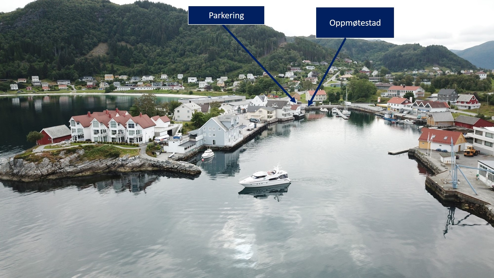 Aerial view of a waterfront town with a boat, labeled parking and meeting spot.