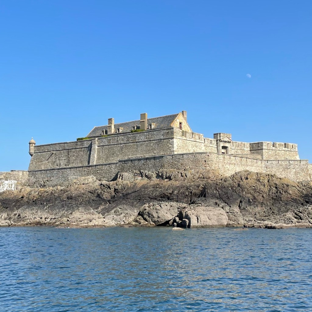 Stone fortress on rocky shore with clear blue sky