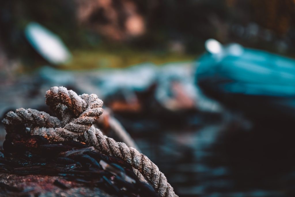 Close-up of a rope tied to a log with a blurred background.
