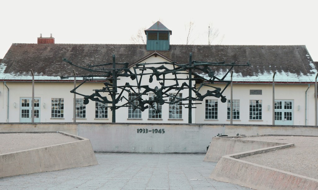 Abstract sculpture in front of a historical building with '1933-1945' written on it.