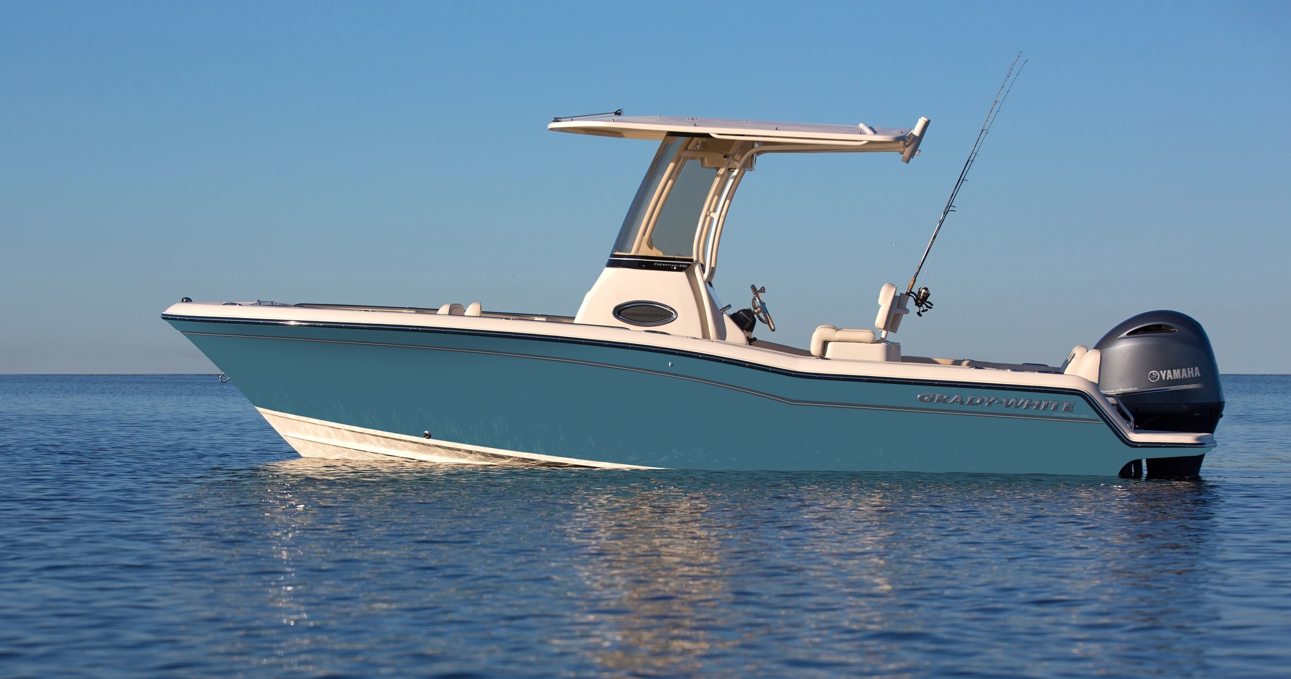 Blue and white motorboat on calm water under clear sky.