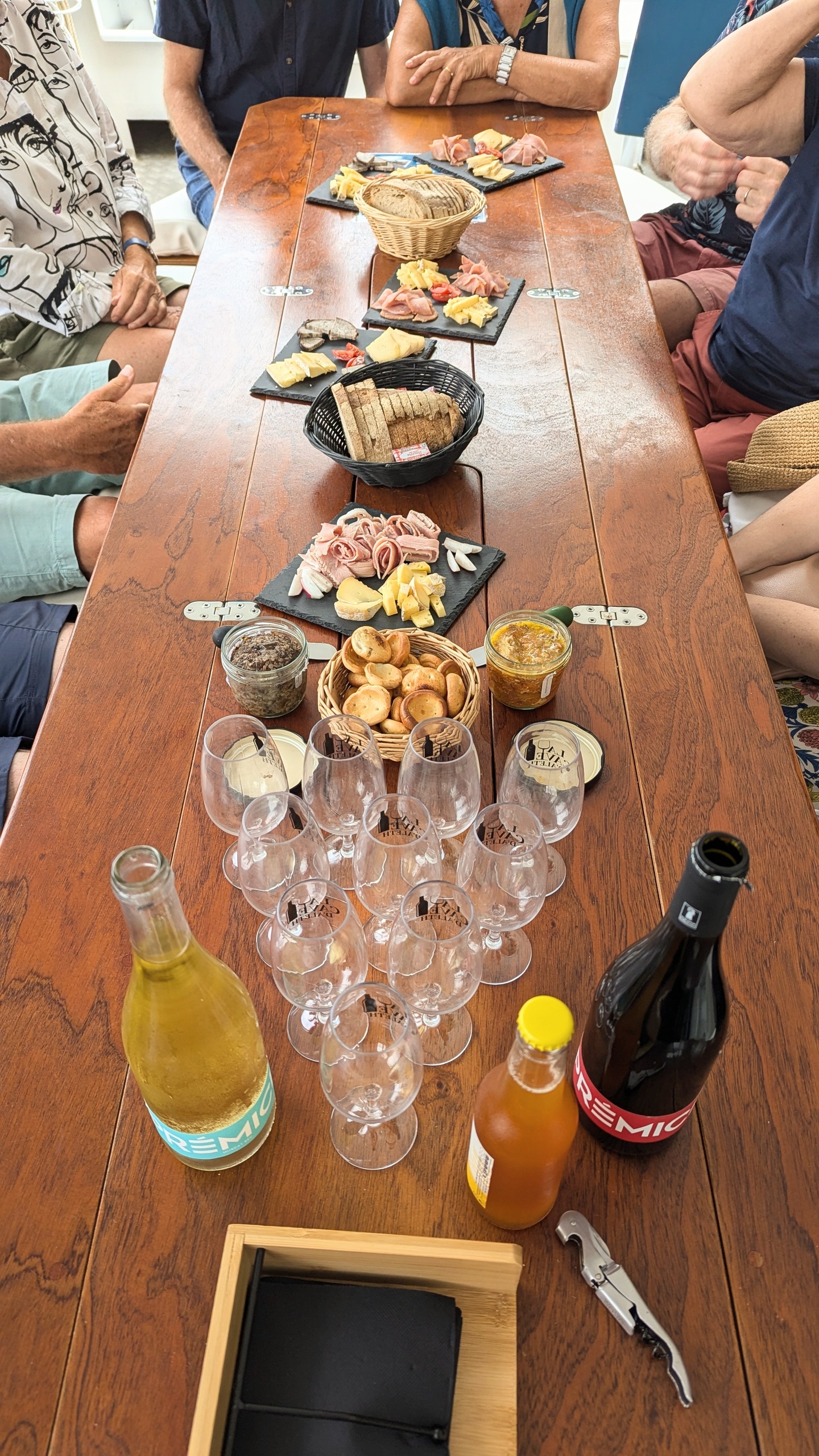 People seated around a table with snacks, wine glasses, and drinks.