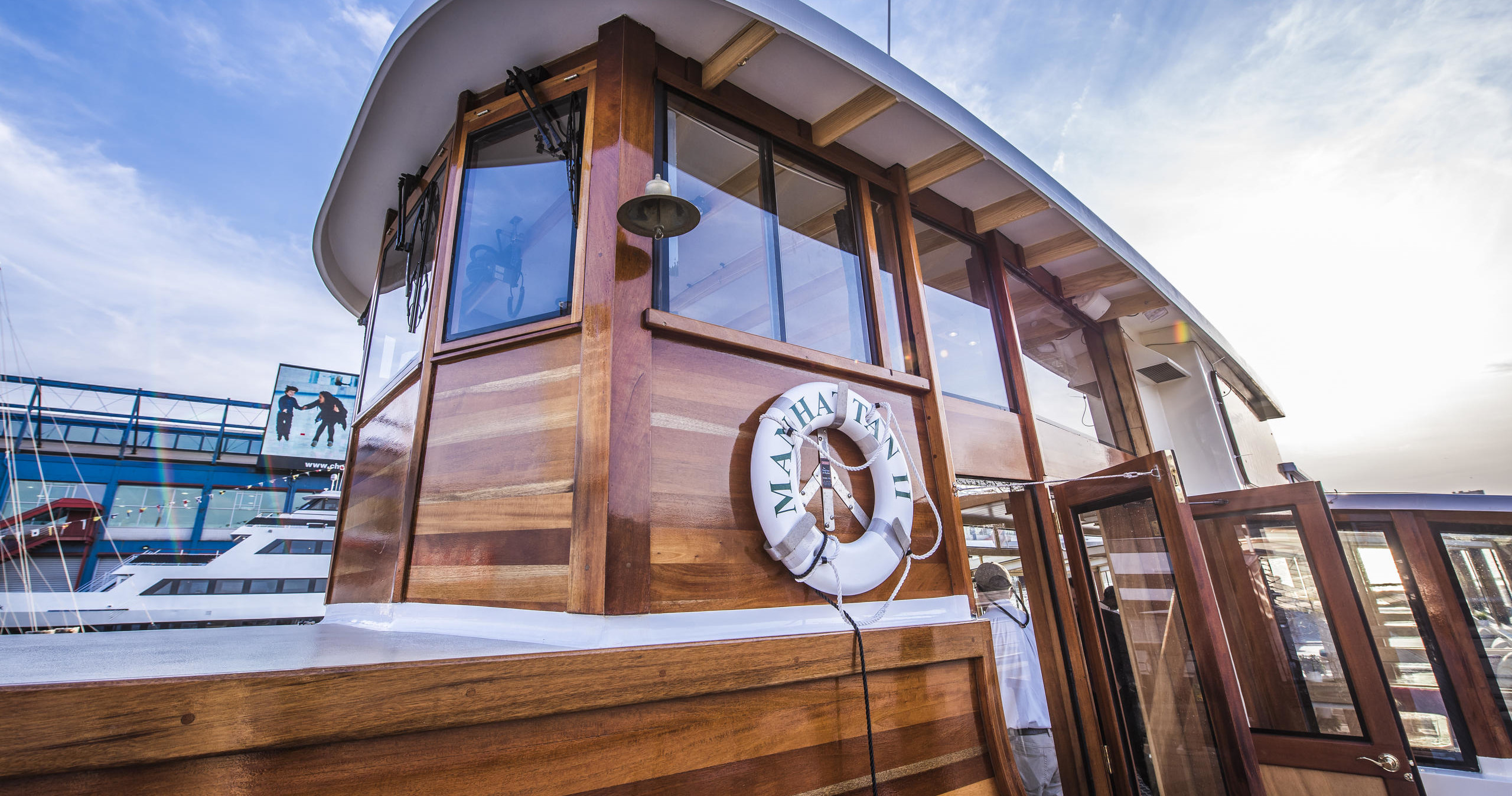 Wooden boat cabin with a life ring, moored at a marina.