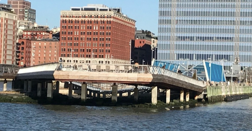 Pier over water with buildings in the background.