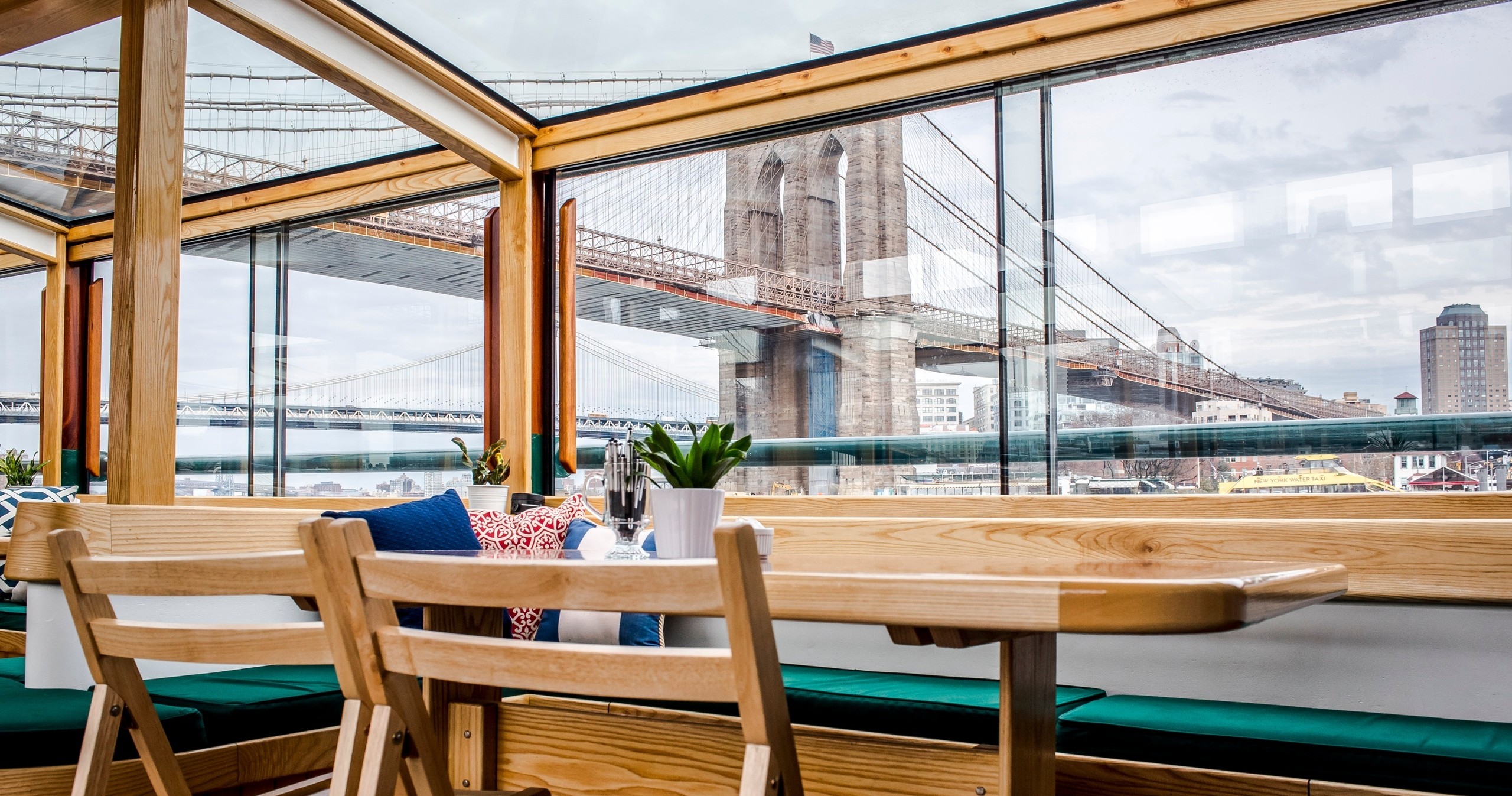 Table in room with large windows overlooking a bridge.