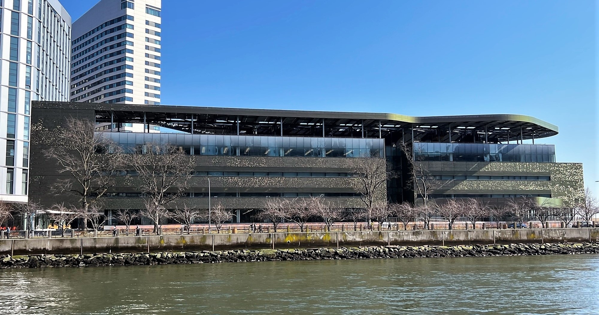 Modern building by a riverside with clear sky background.