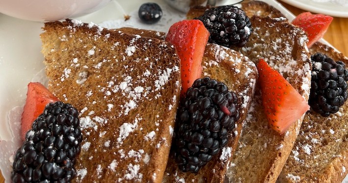 Toast with blackberries, strawberries, and powdered sugar.