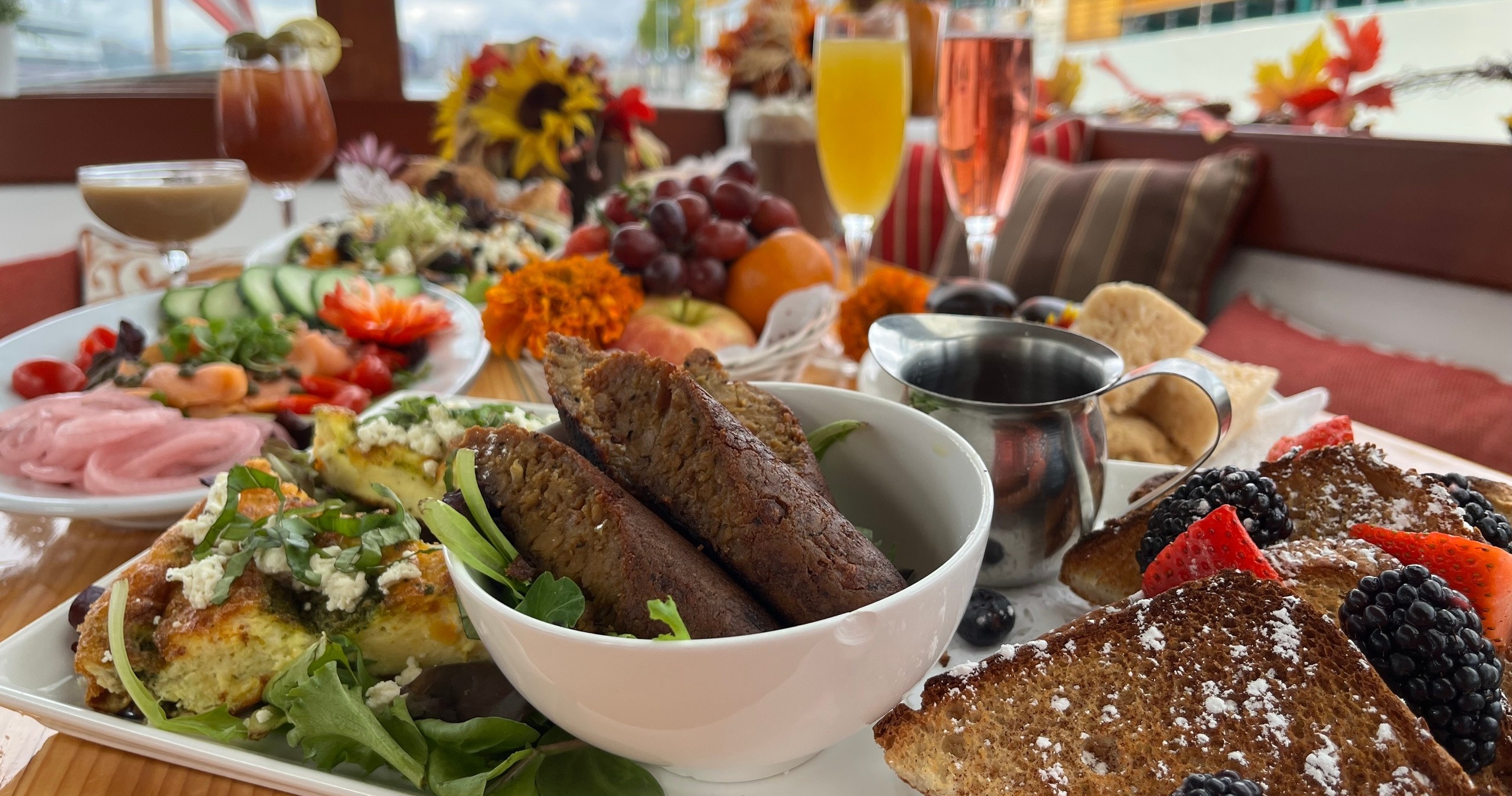 Breakfast spread with fruit, drinks, and various dishes on a table.