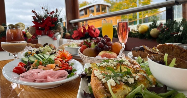 Assorted brunch dishes and drinks on a table with festive decorations.