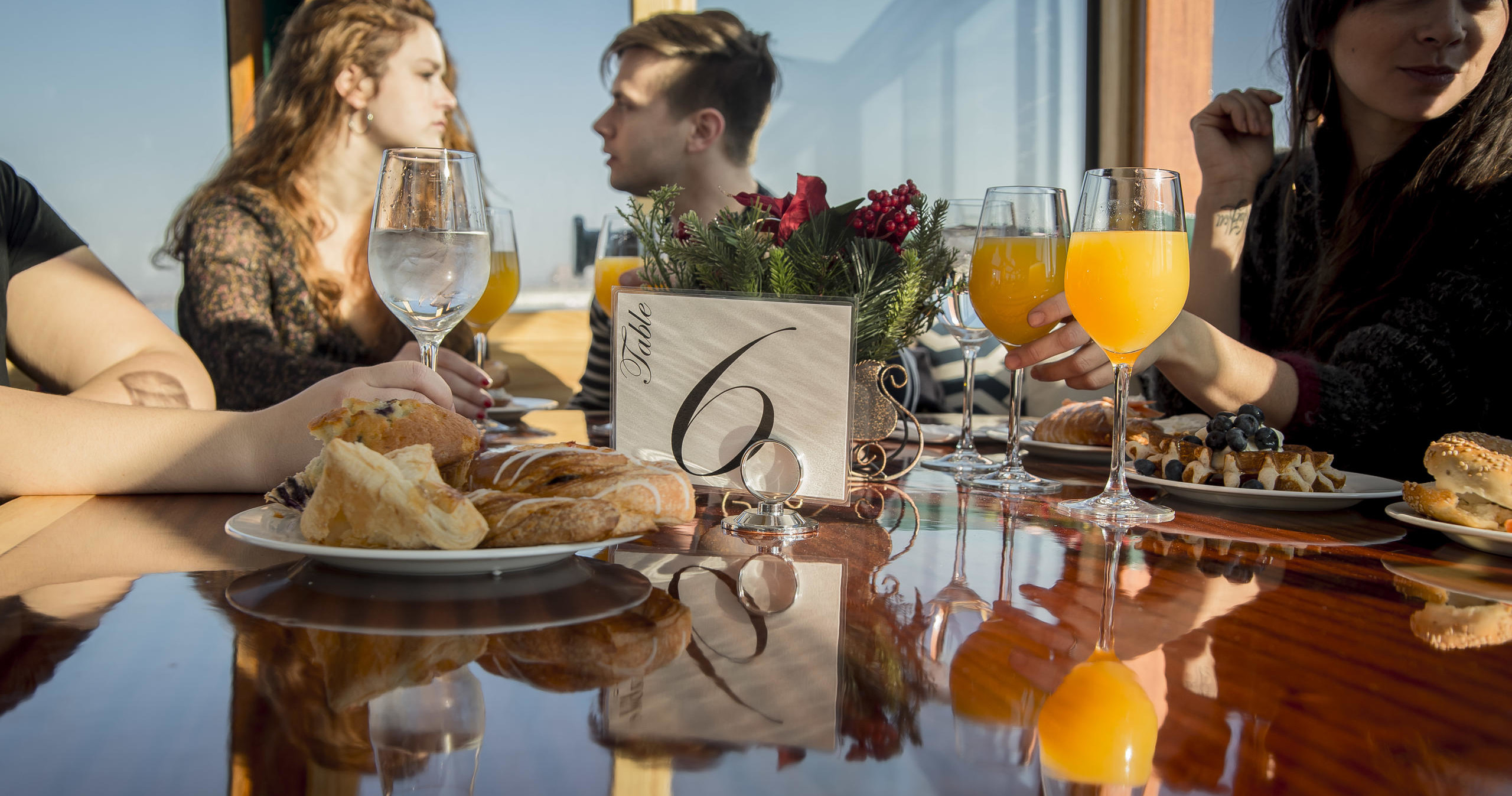 Group at a table with food, drinks, and a table number 6.
