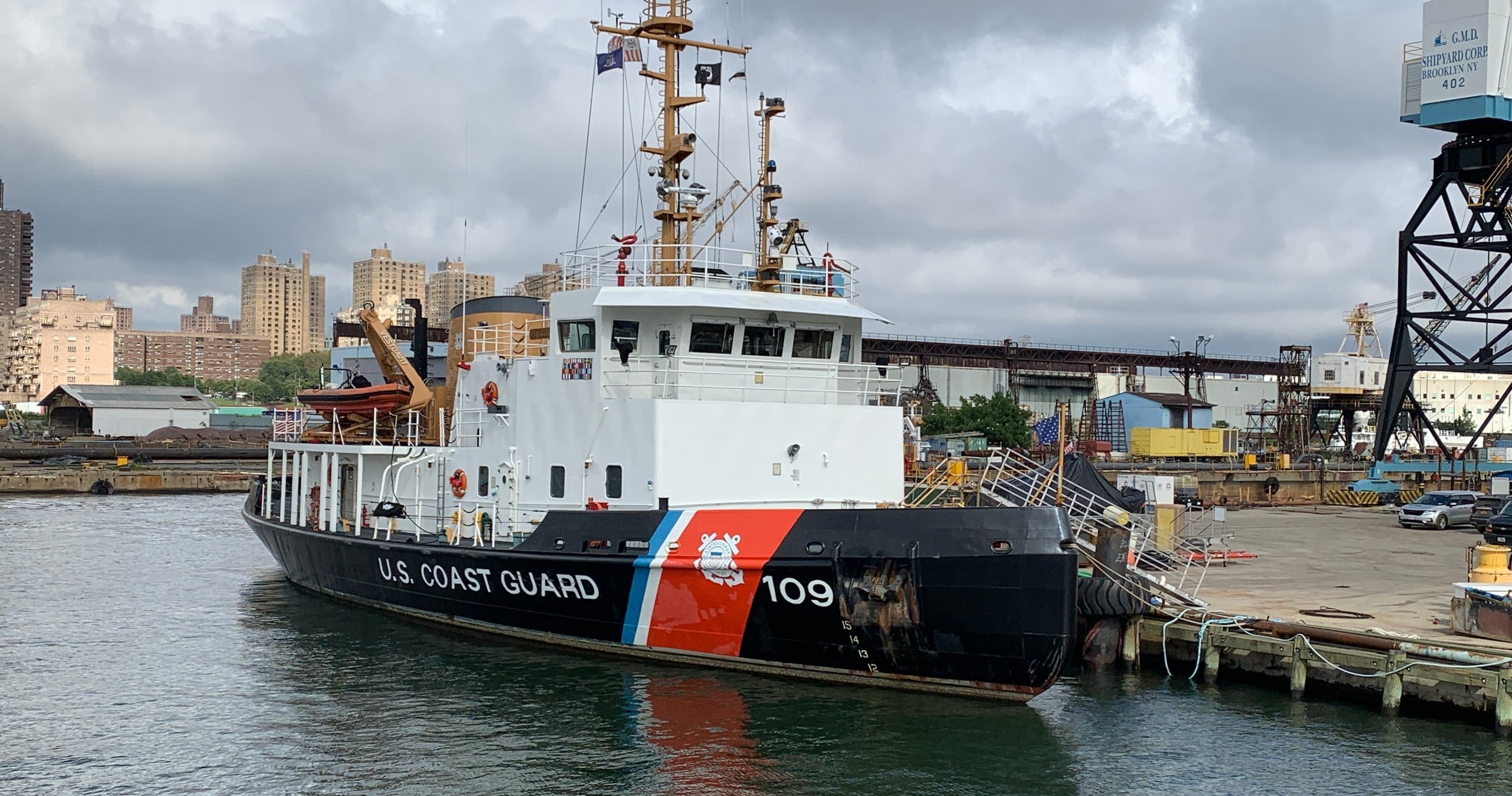 U.S. Coast Guard ship docked in an industrial port area.