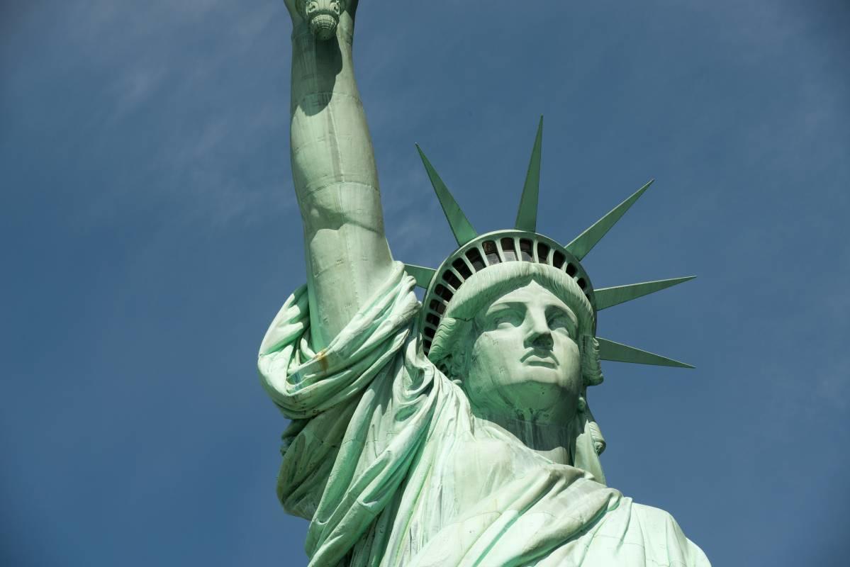 Close-up of the Statue of Liberty against a clear blue sky.