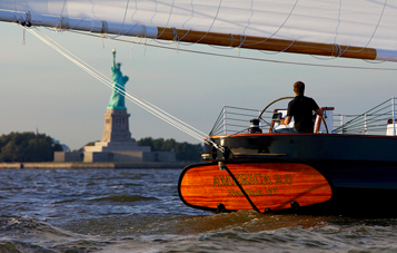 Person sailing near Statue of Liberty on a sailboat
