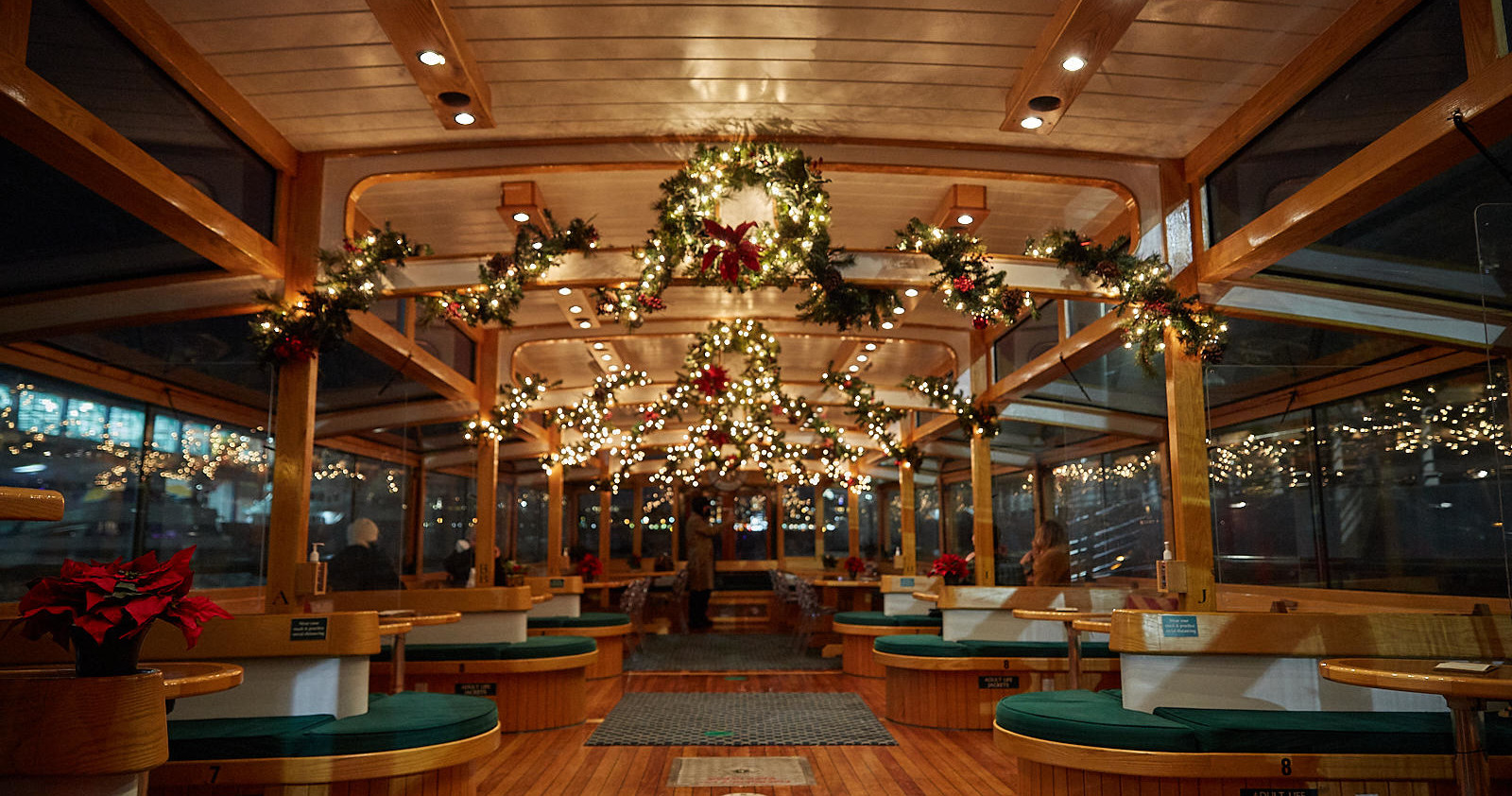 Festively decorated ferry interior with lights and garlands.