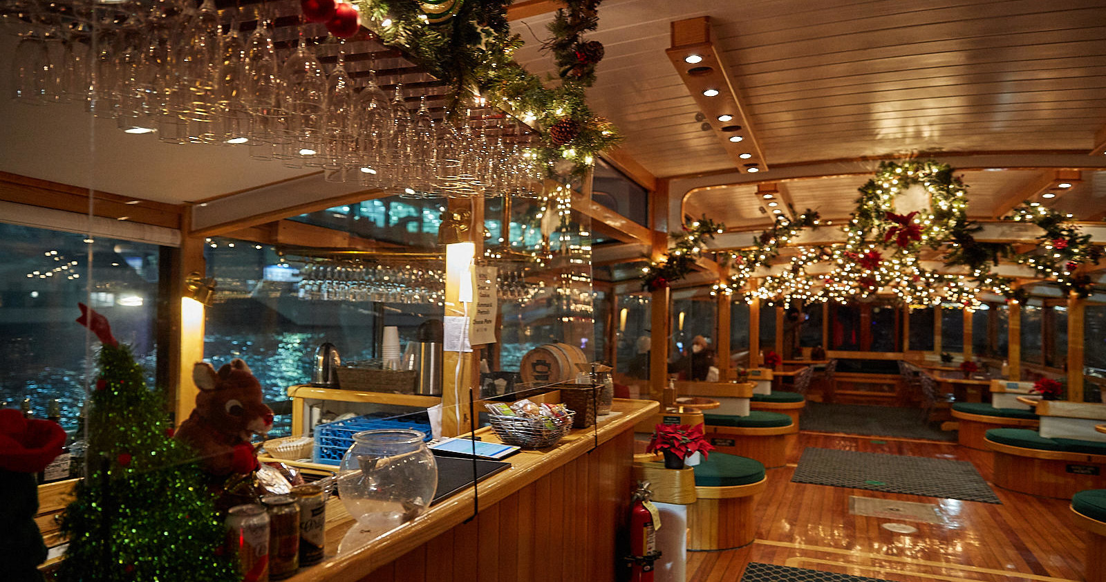 Festively decorated boat interior with lights, garlands, and wood finishes.