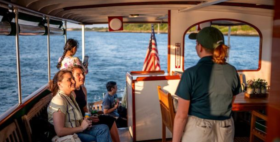 People sitting on a boat with an American flag, water view.