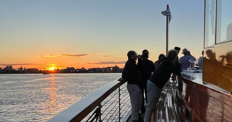 People on a boat enjoying a sunset over the water.