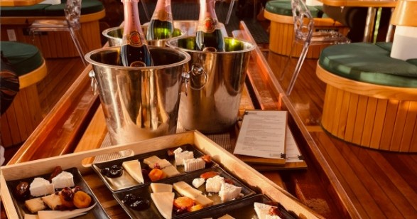Cheese platters and champagne bottles on a wooden table.