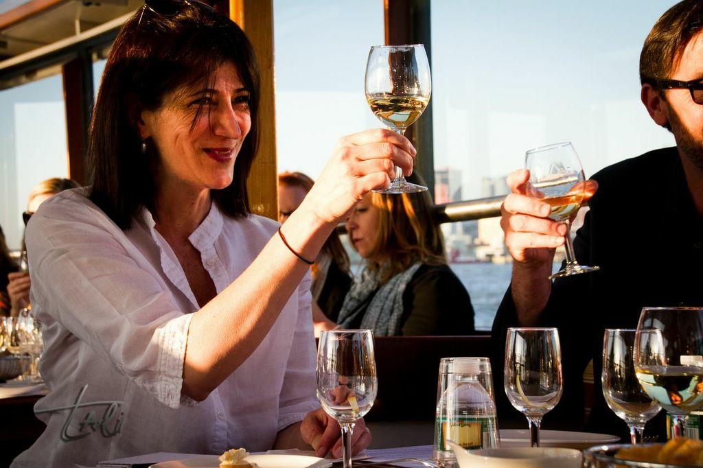 Two people clinking glasses at an outdoor restaurant.