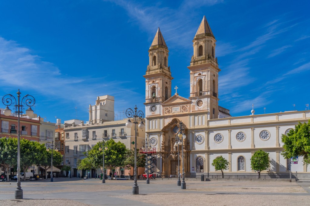 A historic church with twin towers in a sunny plaza.