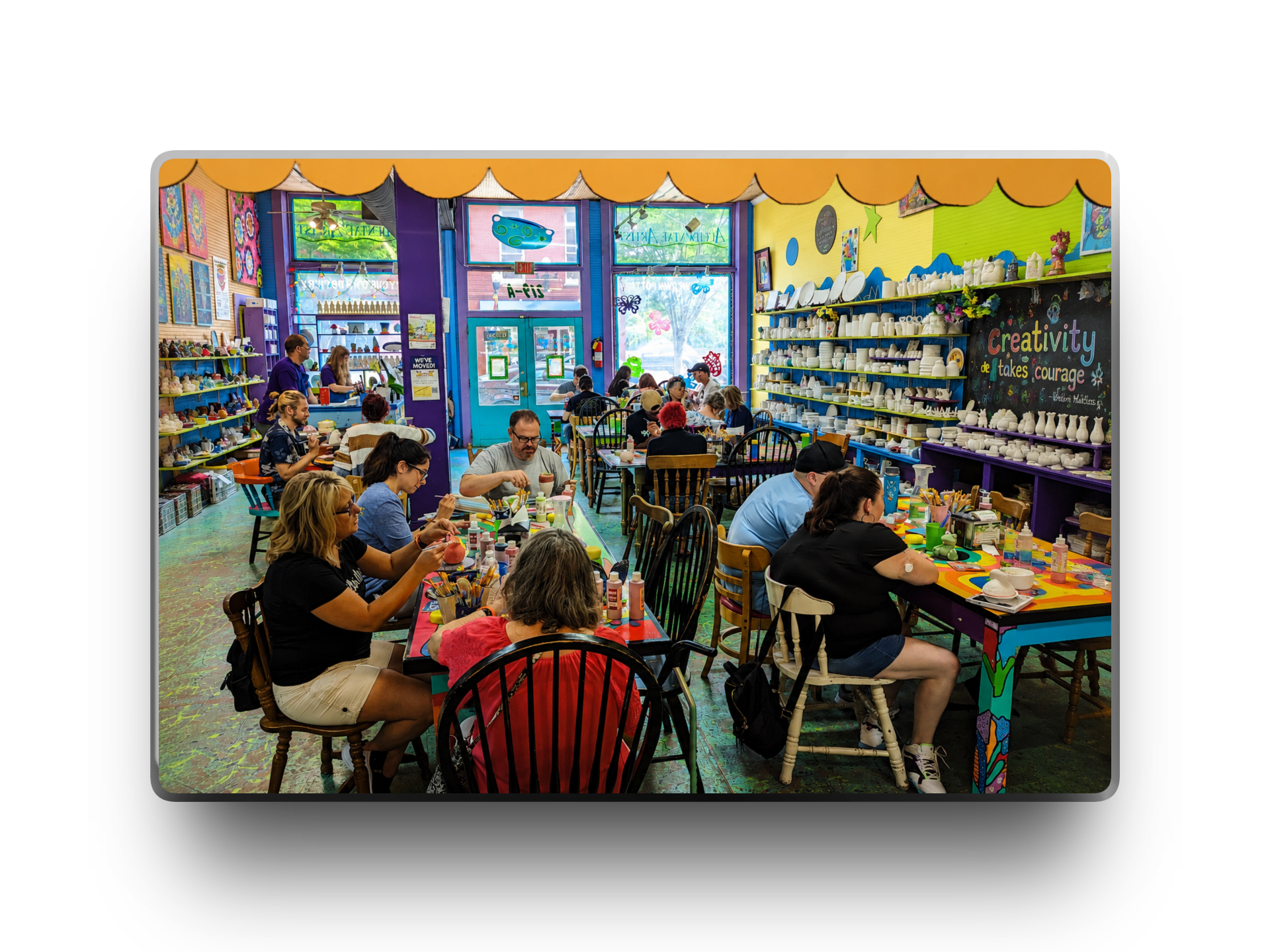 People painting pottery in a colorful art studio.